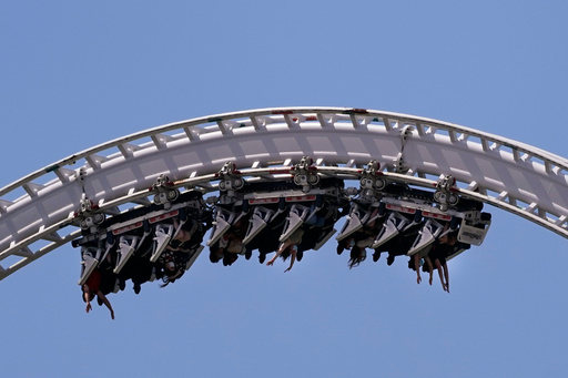 FILE - Visitors ride a roller coaster at Six Flags Magic Mountain in Valencia, Calif., April 1, 2021. (AP Photo/Jae C. Hong, File) FILE - Visitors ride a roller coaster at Six Flags Magic Mountain in Valencia, Calif., April 1, 2021. (AP Photo/Jae C. Hong, File)