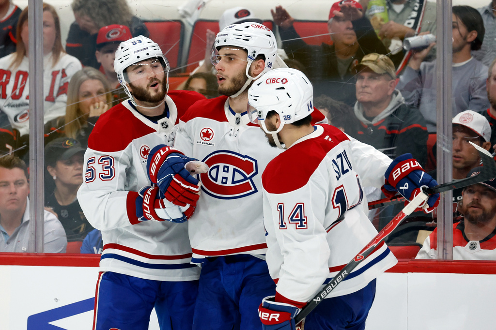 Montréal Canadiens' Juraj Slafkovský (20), center, celebrates his goal with Nick Suzuki (14) and Noah Dobson (53) during the third period in Game 1 of the Eastern Conference finals NHL hockey Stanley Cup playoffs series against the Carolina Hurricanes in Raleigh, N.C., Thursday, May 21, 2026. (AP Photo/Karl DeBlaker)