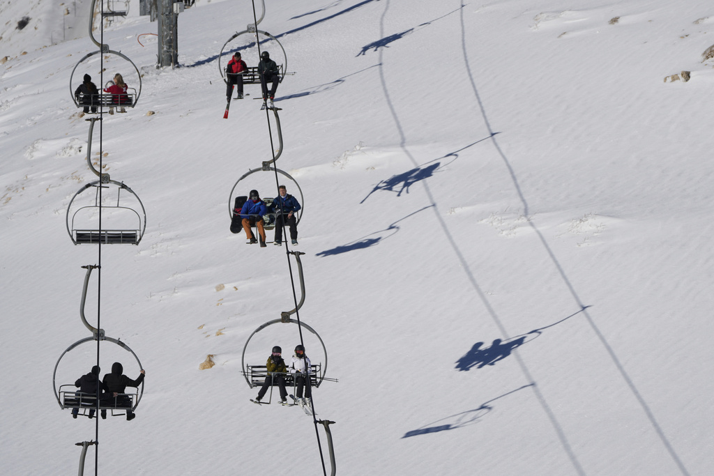 Skiers ride a chairlift over the slopes at the Mzaar-Kfardebian ski resort northeast of Beirut, Lebanon, Saturday, Jan. 3, 2026. (AP Photo/Hassan Ammar)