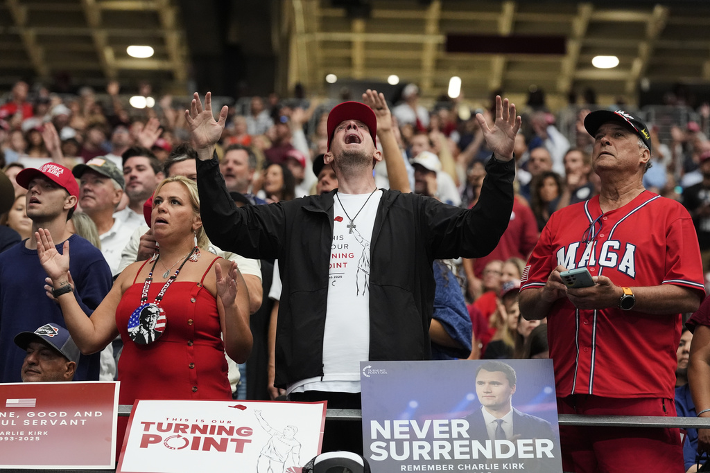 A man listens during a worship song before the start of a memorial for conservative activist Charlie Kirk, Sunday, Sept. 21, 2025, at State Farm Stadium in Glendale, Ariz. (AP Photo/Ross D. Franklin)