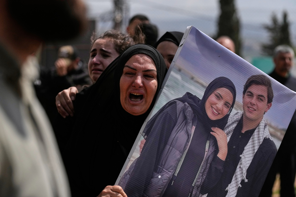 A woman mourns during a mass funeral for Hezbollah fighters and civilians who were killed in the war between Hezbollah and Israel, in Bazouriyeh village, south Lebanon, Monday, April 20, 2026. (AP Photo/Mohammed Zaatari)c