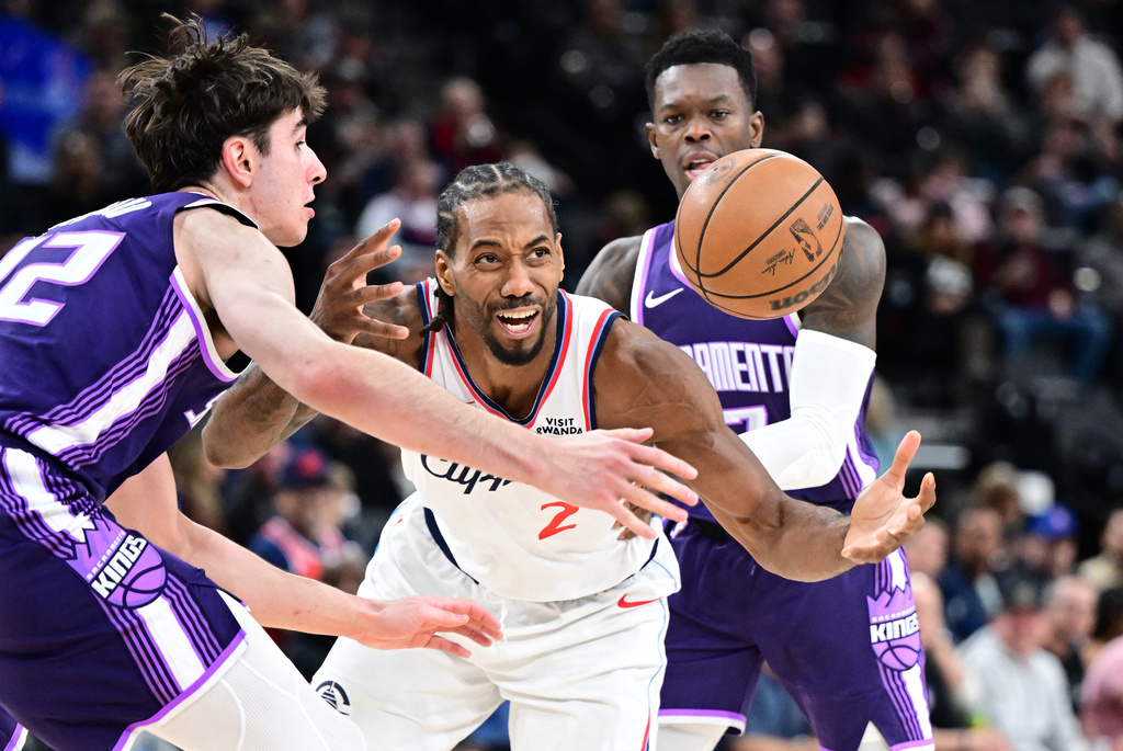 Los Angeles Clippers forward Kawhi Leonard (2) is fouled by by Sacramento Kings guard Dennis Schröder, right, as center Maxime Raynaud helps on defense in the second half of an NBA basketball game Tuesday, Dec. 30, 2025, in Inglewood, Calif. (AP Photo/Wally Skalij)