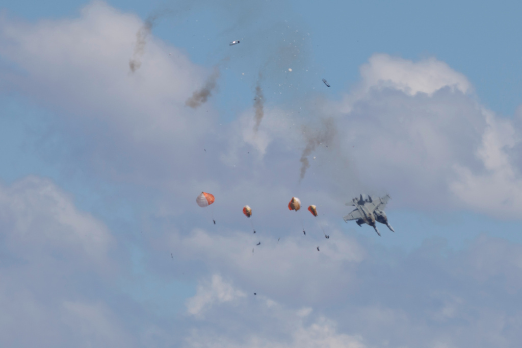Crew members parachute down after two U.S. Navy planes collided during an air show at the Mountain Home Air Force Base, Sunday, May 17, 2026, near Mountain Home, Idaho. (Henk Zuurbier via AP)