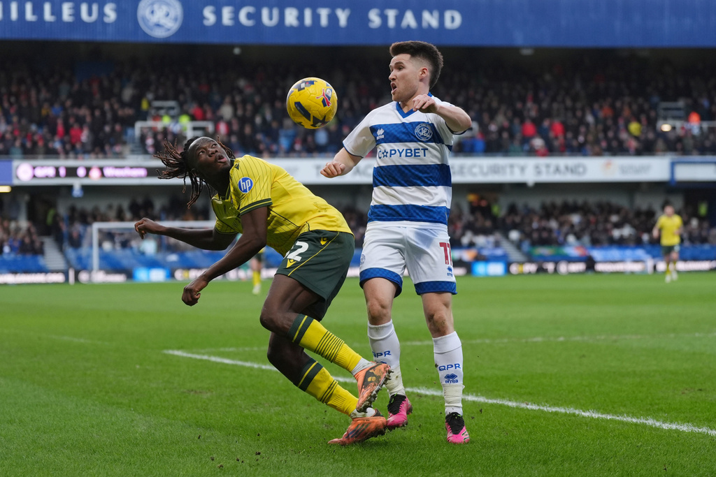 Wrexham's Issa Kabore, left, and Queens Park Rangers' Paul Smyth battle for the ball during the Sky Bet Championship soccer match between Queens Park Rangers and Wrexham in London, Saturday Jan. 24, 2026. (Ben Whitley/PA via AP)
