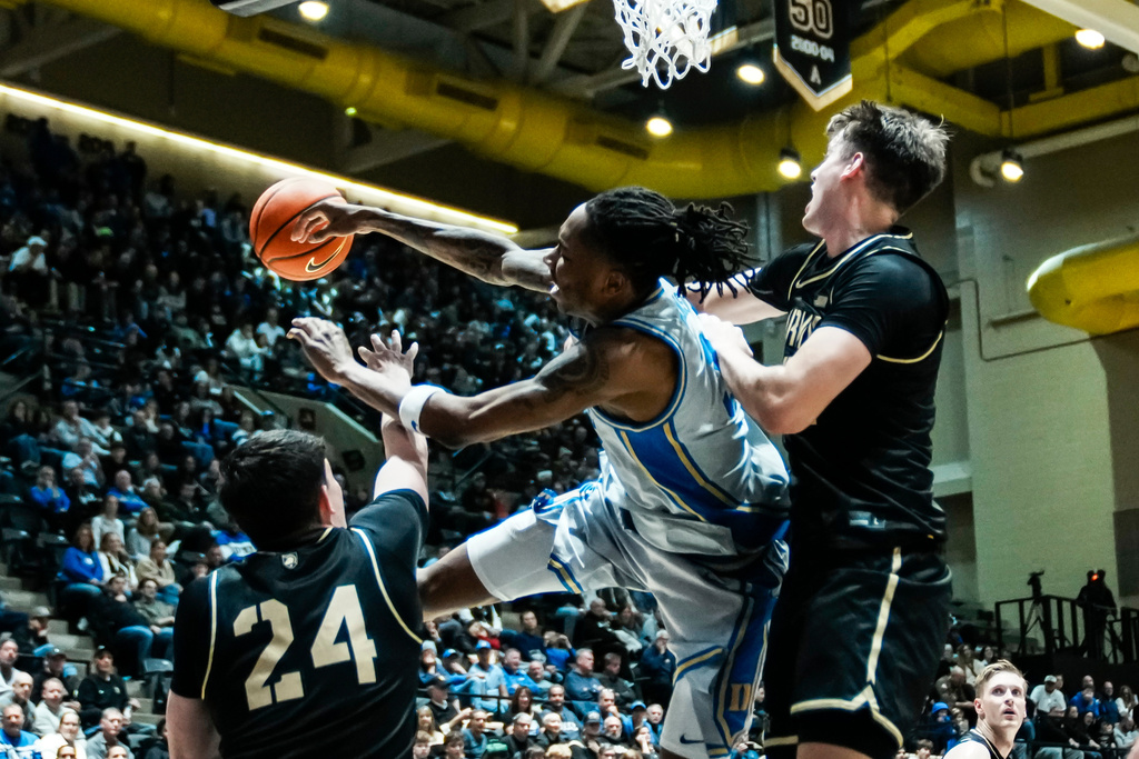 Duke's Isaiah Evans, center, passes the ball over Army's Alex Engro (24) and Tate Laczkowski during the second half of an NCAA college basketball game at West Point. Tuesday, Nov. 11, 2025, New York. (AP Photo/Eduardo Munoz Alvarez)