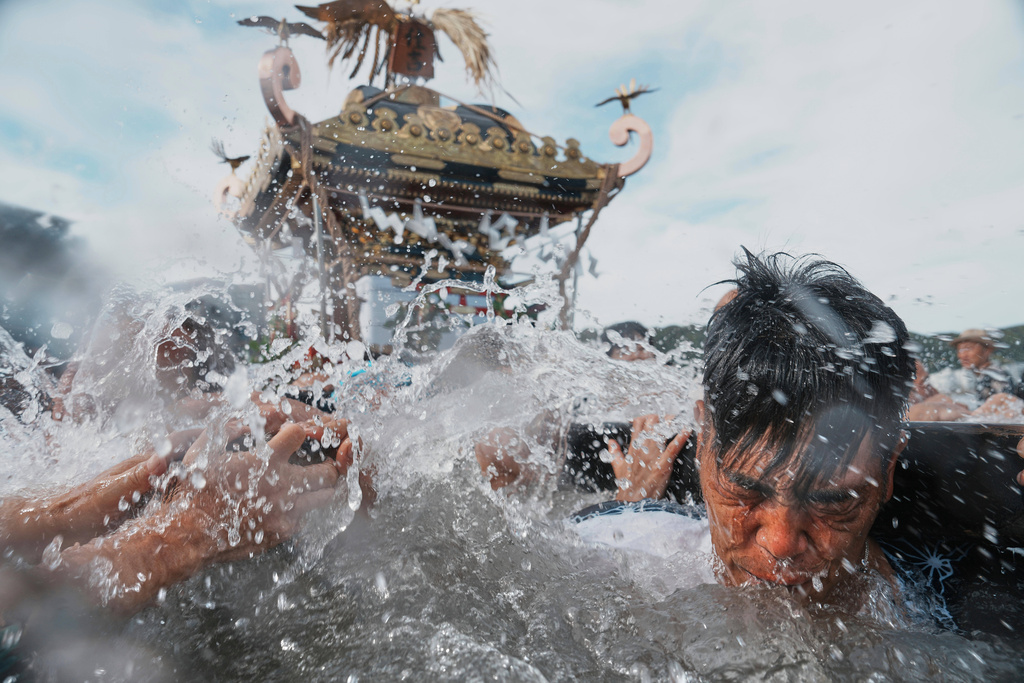 Participants carry a portable shrine, or mikoshi, into the sea during a purification rite at the annual Kurihama Sumiyoshi Shrine Festival at Kurihama, Yokosuka city, south of Tokyo, July 27, 2025. (AP Photo/Eugene Hoshiko, File)