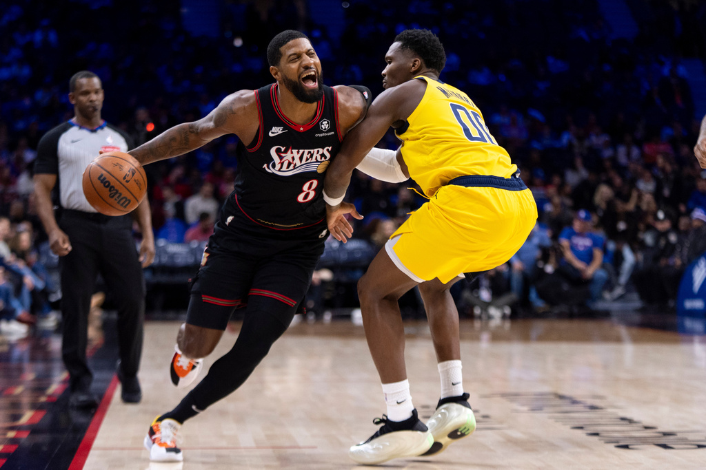 Philadelphia 76ers' Paul George, left, drives to the basket with Indiana Pacers' Bennedict Mathurin, right, defending during the first half of an NBA basketball game, Friday, Dec. 12, 2025, in Philadelphia. (AP Photo/Chris Szagola)
