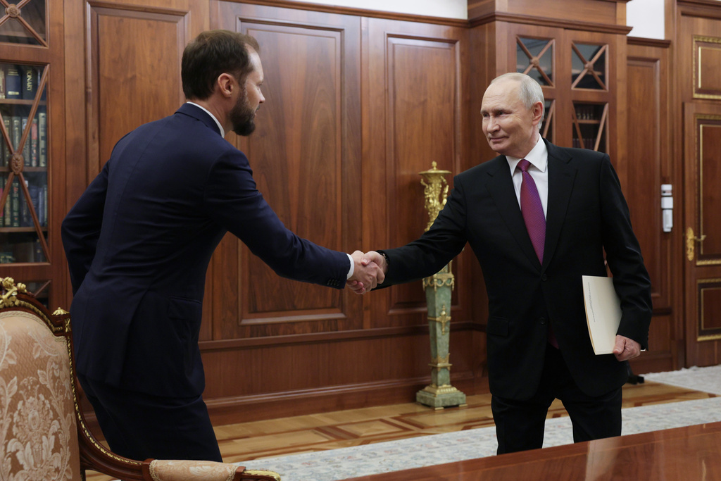 Russian President Vladimir Putin, right, shakes hands with Deputy Head of the Federal Antimonopoly Service (FAS Russia) during their meeting at the Kremlin, on Tuesday, Nov. 4, 2025. (Gavriil Grigorov, Sputnik, Kremlin Pool Photo via AP)