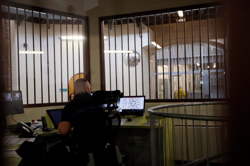 FILE - A prison service guard checks the security screens at the entrance of La Sante prison during a press visit after a four-year renovation project in Paris, Friday, April 12, 2019. (AP Photo/Francois Mori, File)