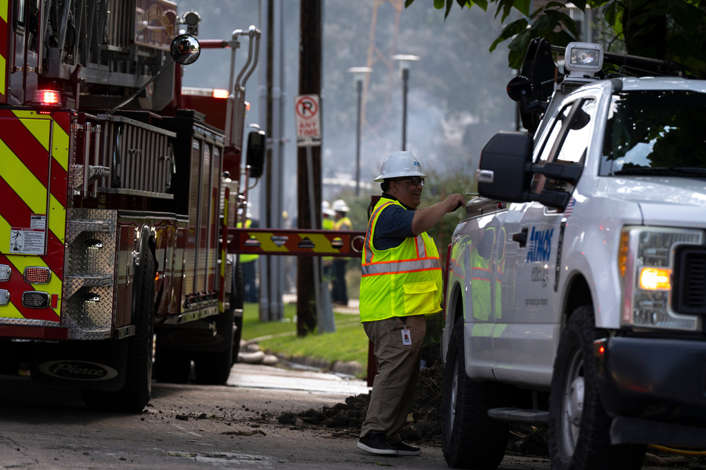 An Atmos Energy employee works at the scene of a large fire at an apartment complex in Dallas, Thursday, May 28, 2026. (AP Photo/Gabriela Passos)