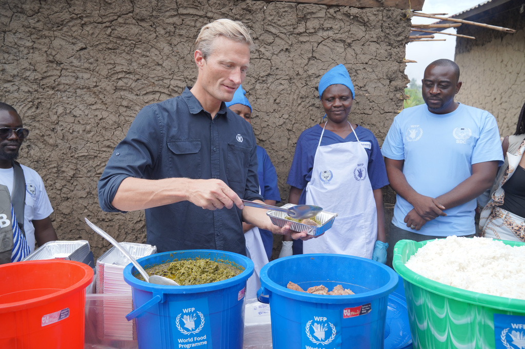 Carl Skau, acting executive director of the World Food Programme, pepares a container of food at the Rwampara Ebola treatment center in Ituri, eastern Congo, Wednesday, July 29, 2026. (AP Photo/Dieudonne Dirole)