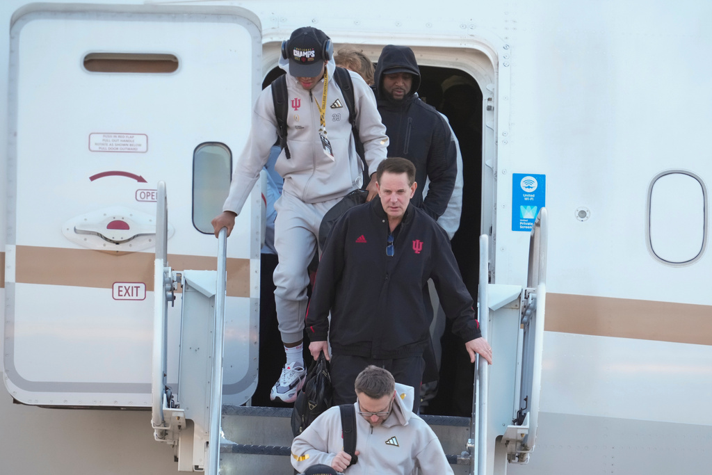 Indiana head coach Curt Cignetti, walks off the plane after the team arrived at the Indianapolis International Airport in Indianapolis, Tuesday, Jan. 20, 2026. (AP Photo/Michael Conroy)