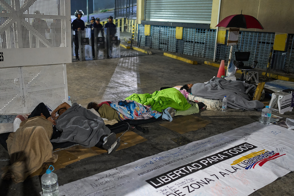 Relatives of detainees camp outside the gates of a Bolivarian National Police detention center, calling for the release of family members who are being held on political grounds, in Caracas, Venezuela, Saturday, Feb. 14, 2026. (AP Photo/Ariana Cubillos)