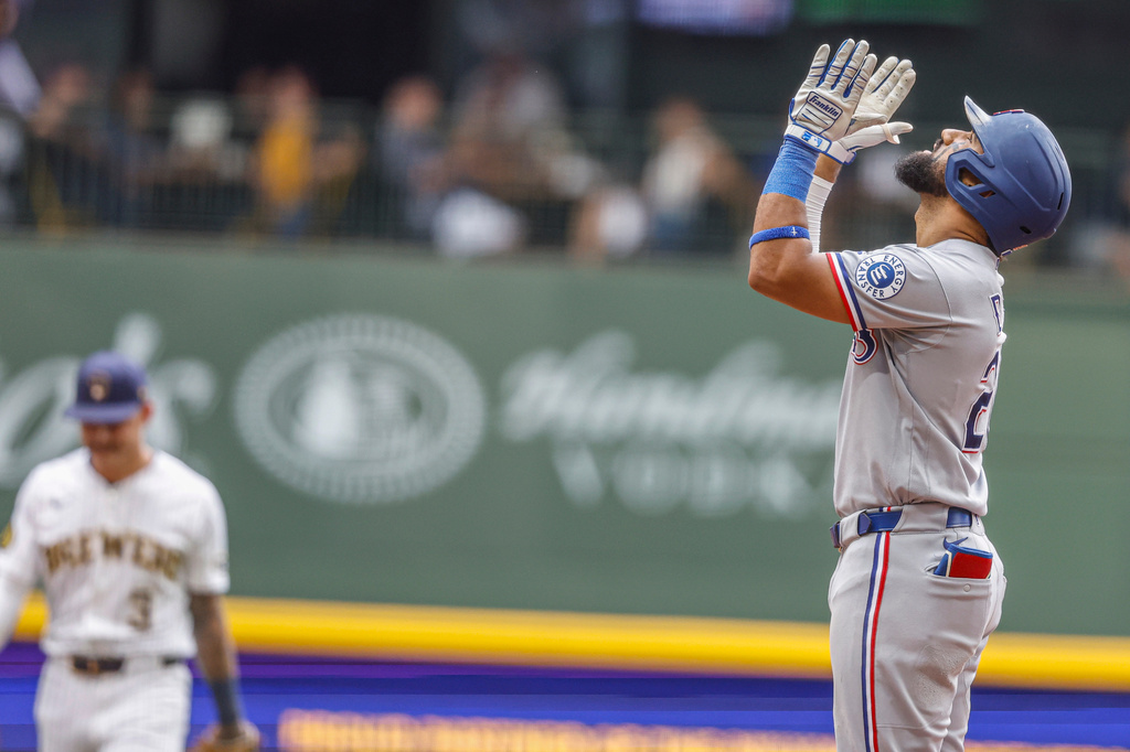 Texas Rangers' Ezequiel Duran, right, reacts after hitting a two-RBI double against the Milwaukee Brewers during the fifth inning of a baseball game Sunday, Aug. 30, 2026, in Milwaukee. (AP Photo/Jeffrey Phelps)