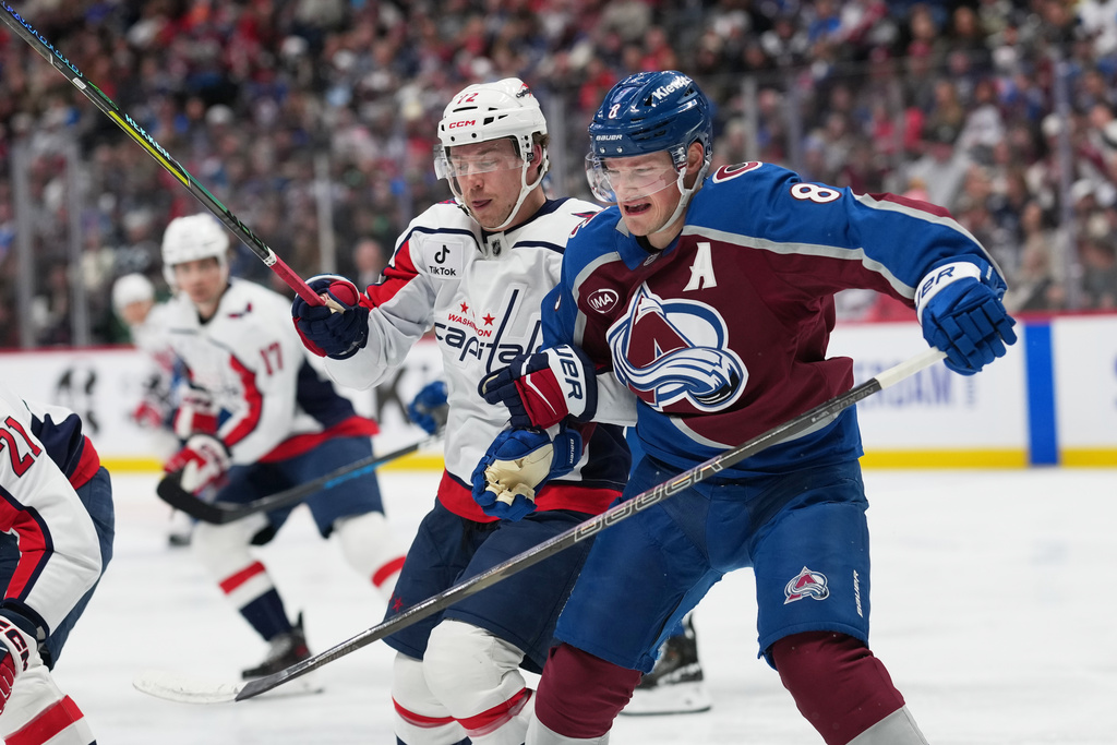 Washington Capitals left wing Anthony Beauvillier, left, and Colorado Avalanche defenseman Cale Makar pursue the puck in the second period of an NHL hockey game, Monday, Jan. 19, 2026, in Denver. (AP Photo/David Zalubowski)