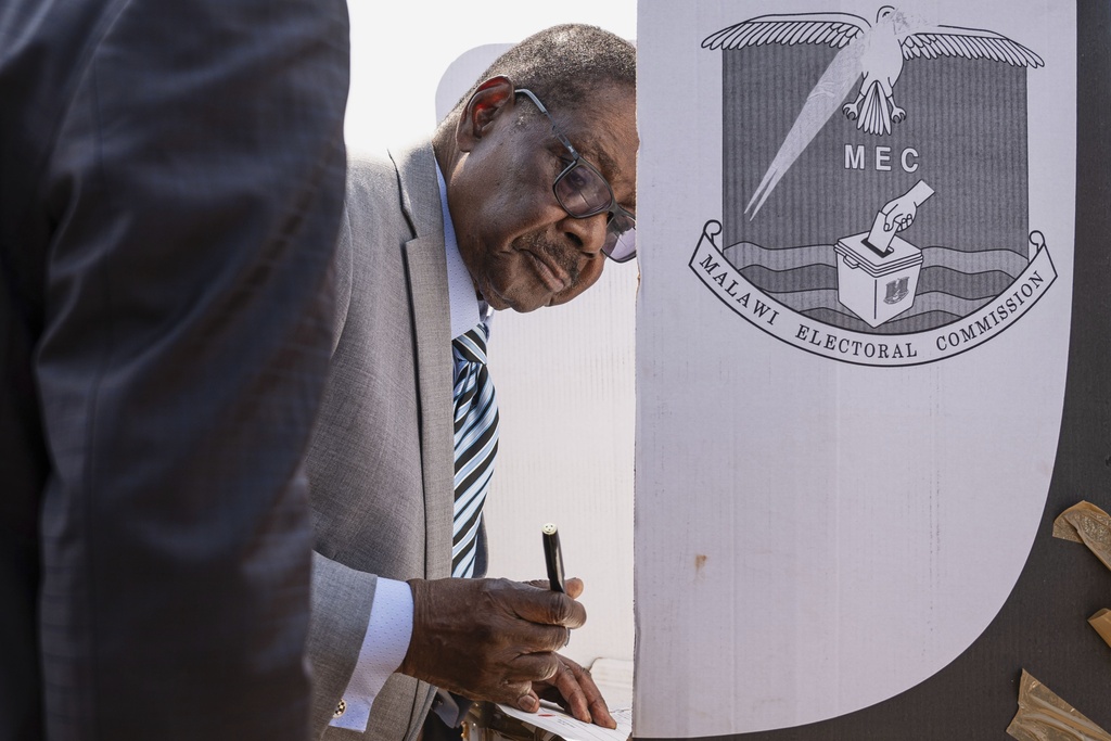Malawi's presidential candidate, former President Peter Mutharika stands on a voting booth as he prepares to cast his vote in Thyolo District, Malawi, Tuesday, Sept. 16, 2025. (AP Photo/Thoko Chikondi)