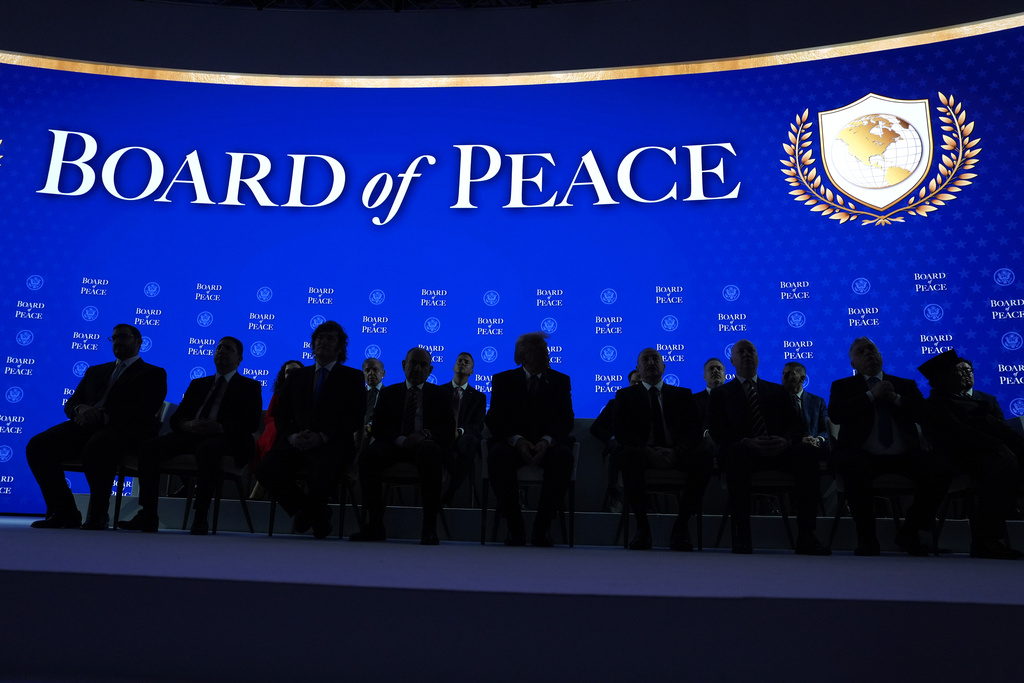 President Donald Trump, center, sits on stage with international leaders after the signing of a Board of Peace charter during the Annual Meeting of the World Economic Forum in Davos, Switzerland, Thursday, Jan. 22, 2026. (AP Photo/Evan Vucci)