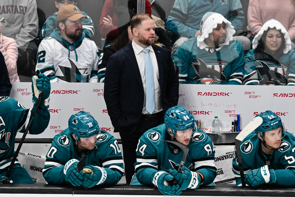 San Jose Sharks head coach Ryan Warsofsky, middle back, during the second period of an NHL hockey game Saturday, Jan. 3, 2026, in San Jose, Calif. (AP Photo/Thien-An Truong)