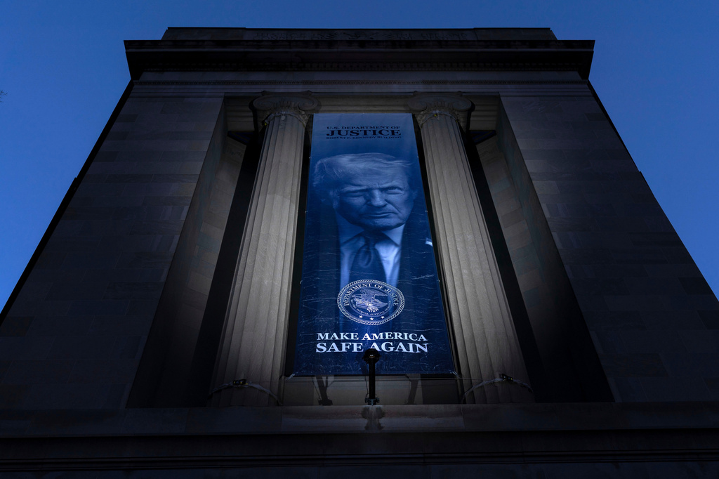 FILE - A banner with a portrait of President Donald Trump is hung from the Department of Justice, March 7, 2026, in Washington. (AP Photo/Jose Luis Magana)