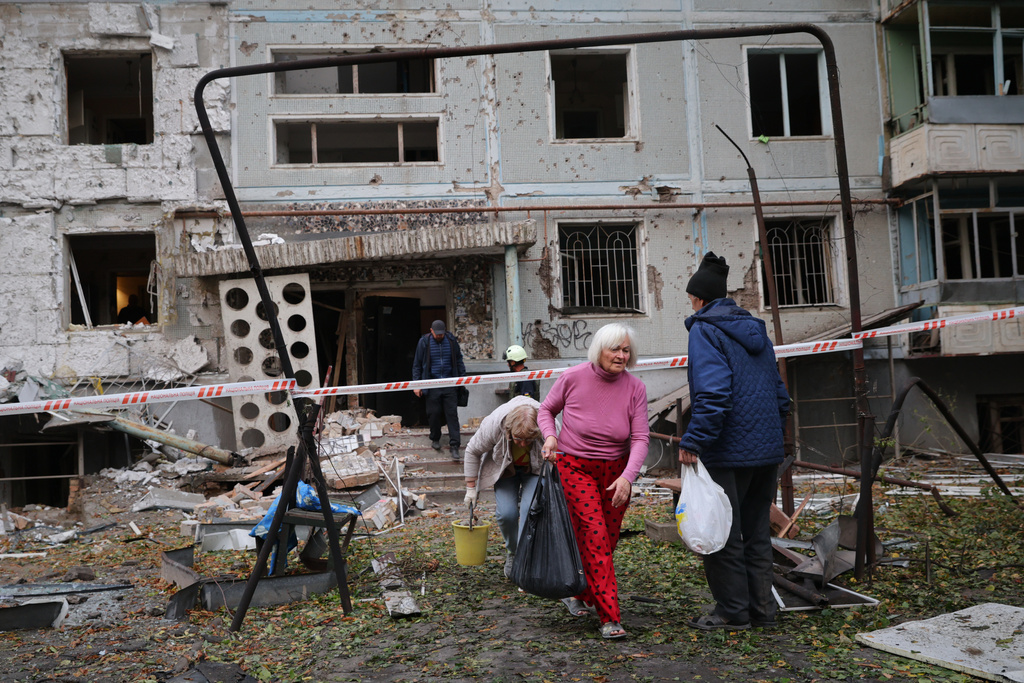 Residents take their belongings from their house destroyed by a Russian strike in Zaporizhzhia, Ukraine, Sunday, Oct. 5, 2025. (AP Photo/Kateryna Klochko)