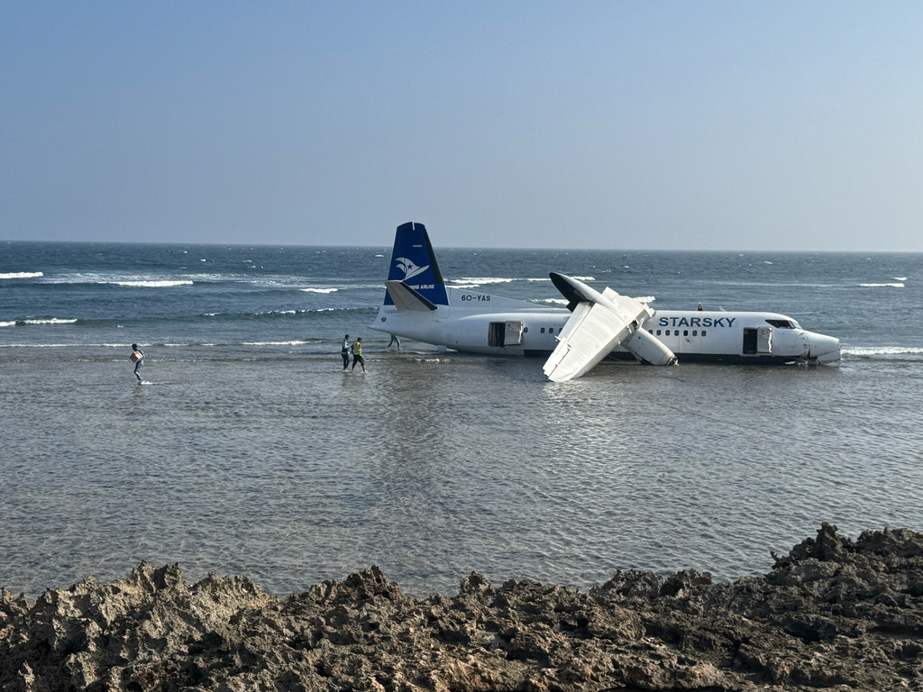 CORRECTS THE PHOTOGRAPHER'S NAME - An aircraft carrying up to 50 people on the shoreline after veering off the runway during an emergency crash-landing at Somalia's main airport in Mogadishu, Somalia, Tuesday, Feb. 10, 2026. (AP Photo/Mohamed Sheikh Nor)