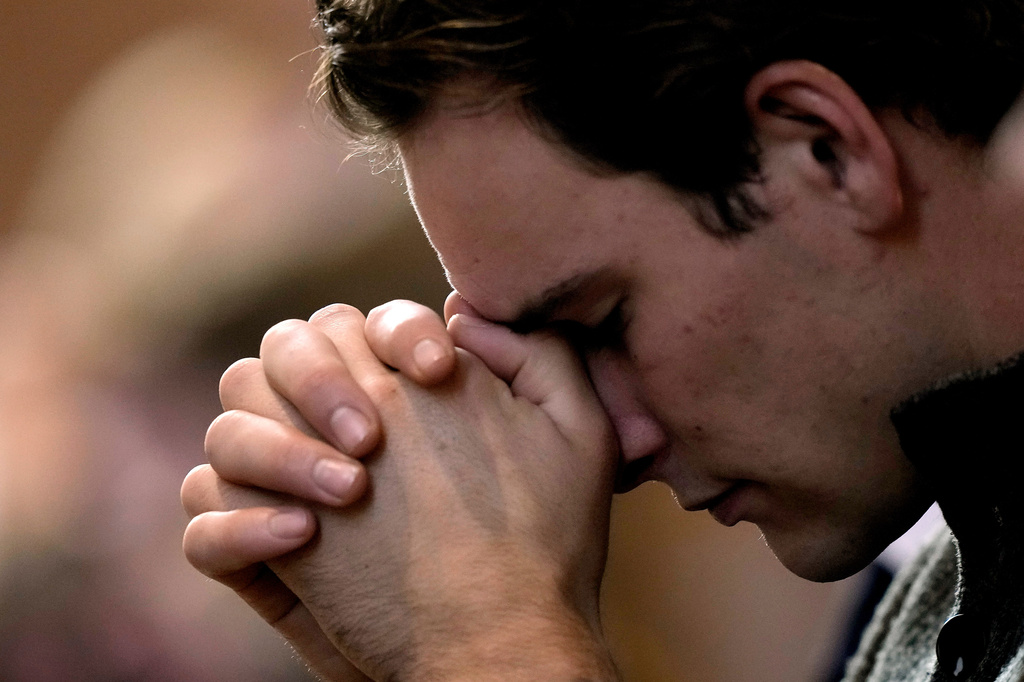 FILE - A man prays during Catholic Mass at Benedictine College, Oct. 29, 2023, in Atchison, Kan. (AP Photo/Charlie Riedel, File)