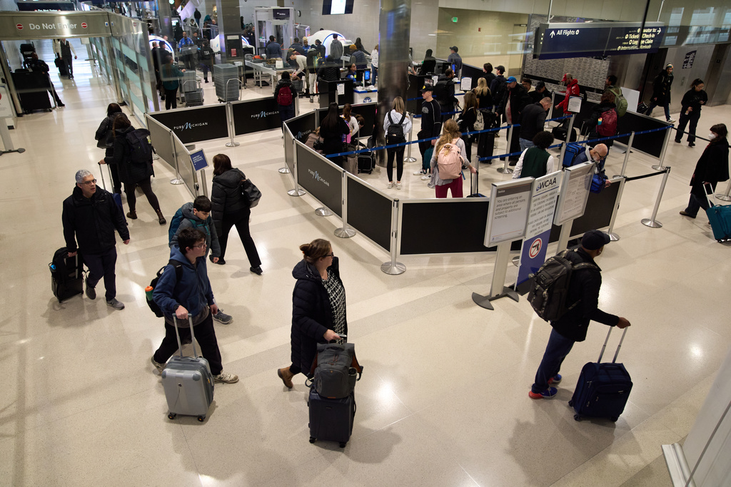 Travelers arrive at Detroit Metropolitan Wayne County Airport Sunday, Nov. 30, 2025, in Romulus, Mich. (AP Photo/Ryan Sun)