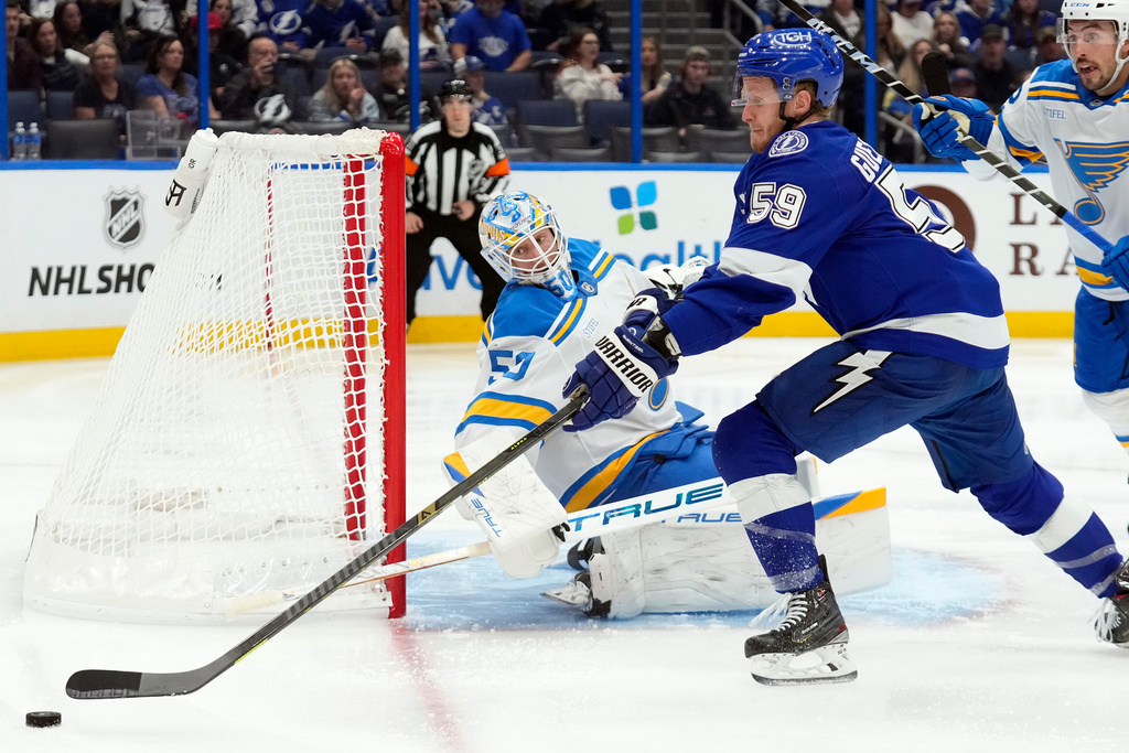 St. Louis Blues goaltender Jordan Binnington (50) makes a save on a shot by Tampa Bay Lightning center Jake Guentzel (59) during the second period of an NHL hockey game Monday, Dec. 22, 2025, in Tampa, Fla. (AP Photo/Chris O'Meara)
