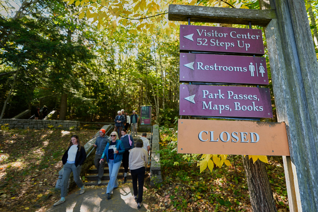 Visitors descend stairs after discovering the visitor center, park store and restrooms are closed at Acadia National Park, Wednesday, Oct. 1, 2025, in Maine. (AP Photo/Robert F. Bukaty)
