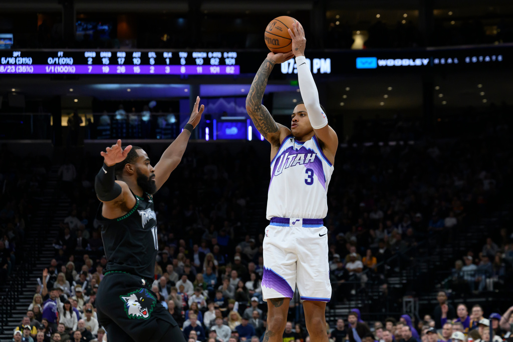 Utah Jazz guard Keyonte George (3) shoots the ball over Minnesota Timberwolves guard Mike Conley, left, during the first half of an NBA basketball game, Monday, Nov. 10, 2025, in Salt Lake City. (AP Photo/Tyler Tate)
