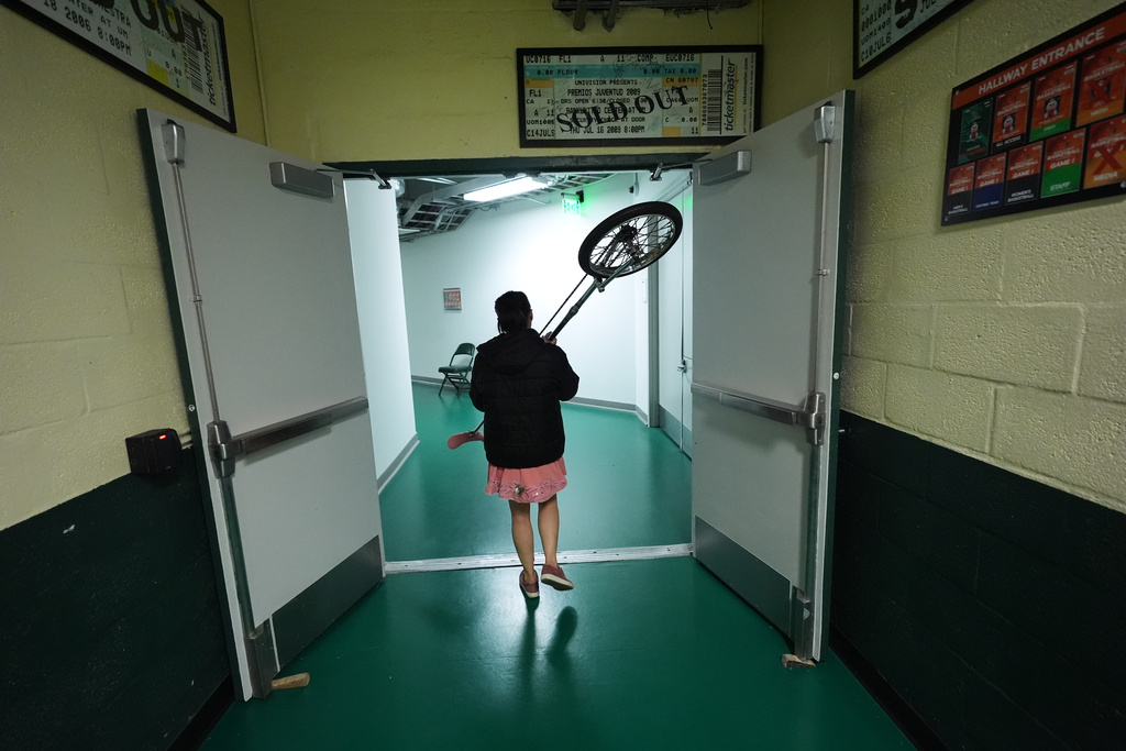 Red Panda carries her unicycle back to her dressing room after performing at halftime of an NCAA college basketball game between Miami and Stanford in Coral Gables, Fla., Wednesday, Jan. 28, 2026. (AP Photo/Rebecca Blackwell)