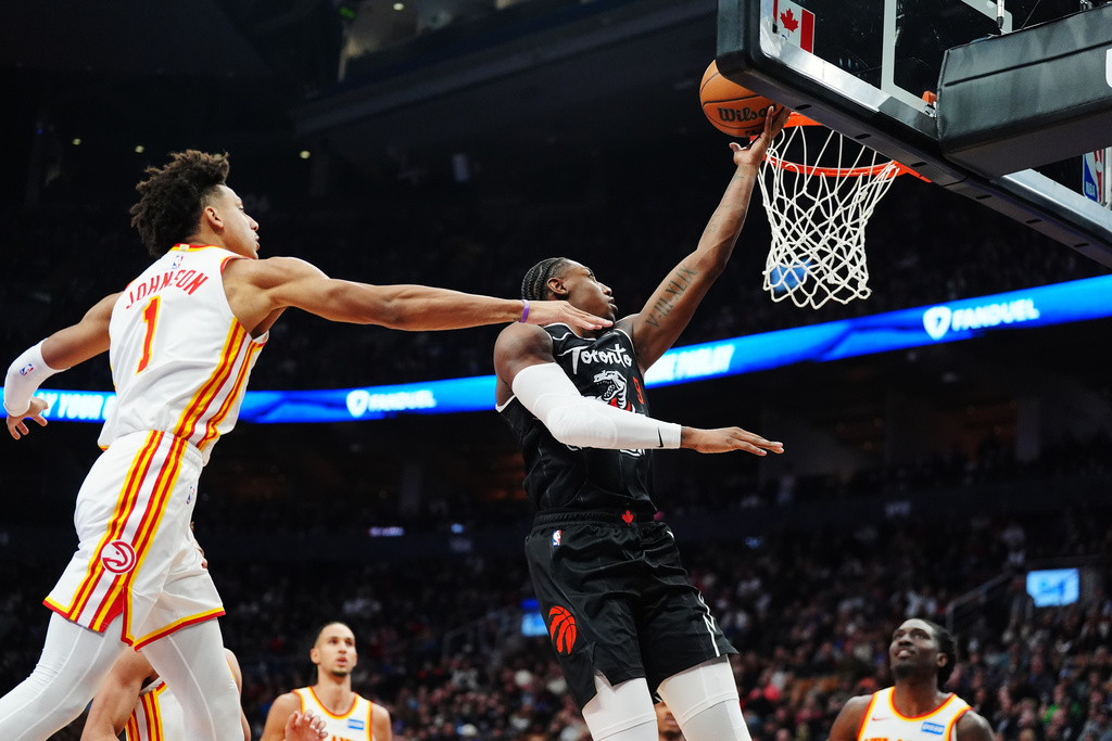 Toronto Raptors' RJ Barrett (9) scores past Atlanta Hawks' Jalen Johnson (1) during the first half of an NBA basketball game in Toronto, Saturday, Jan. 3, 2026. (Frank Gunn/The Canadian Press via AP)