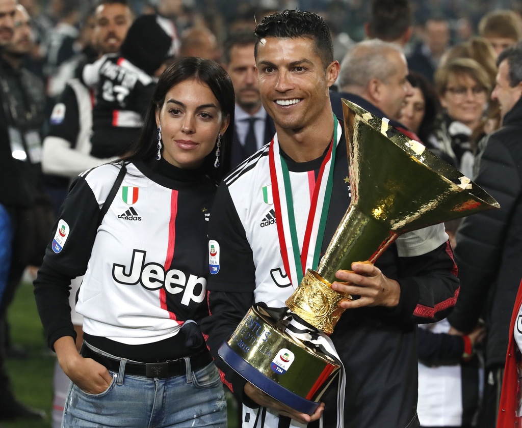 FILE - In this May 19, 2019 file photo, Juventus' Cristiano Ronaldo celebrates with his girlfriend Georgina, left, after winning the Serie A soccer title trophy, at the Allianz Stadium, in Turin, Italy. (AP Photo/Antonio Calanni, File)