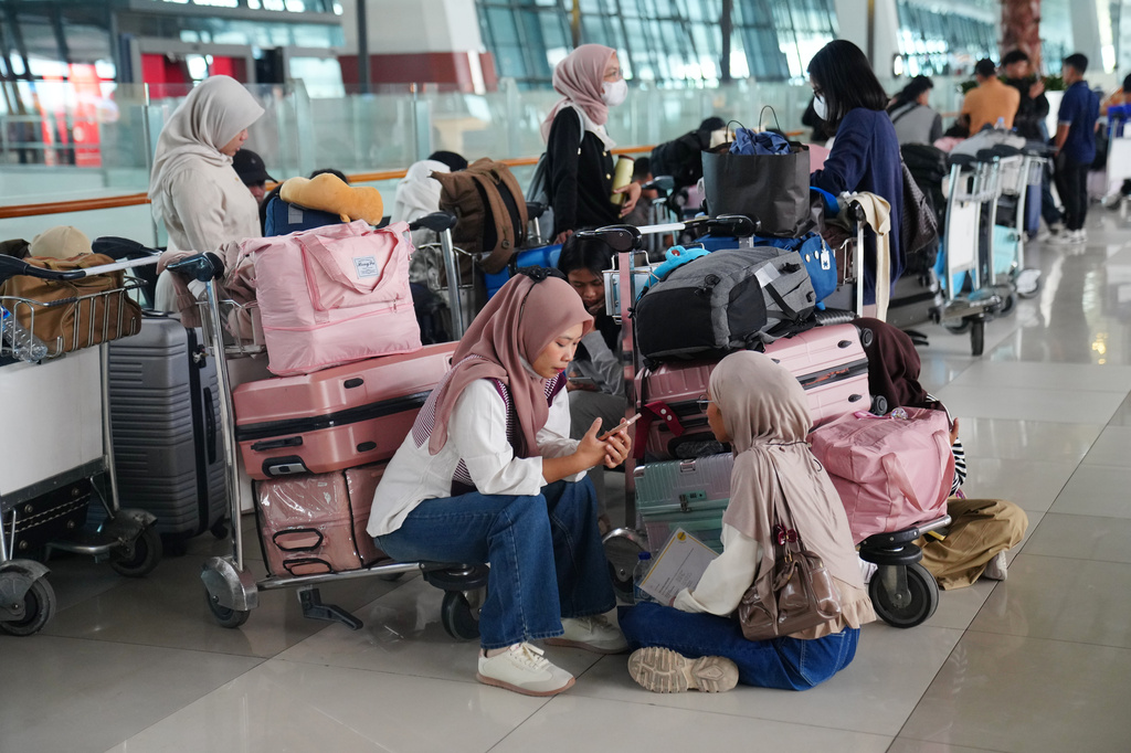 People wait as flights are disrupted due to the eruption of Mount Anak Krakatau, at Soekarno-Hatta International Airport in Tangerang, Indonesia, Monday, Sept. 7, 2026. (AP Photo/Tatan Syuflana)