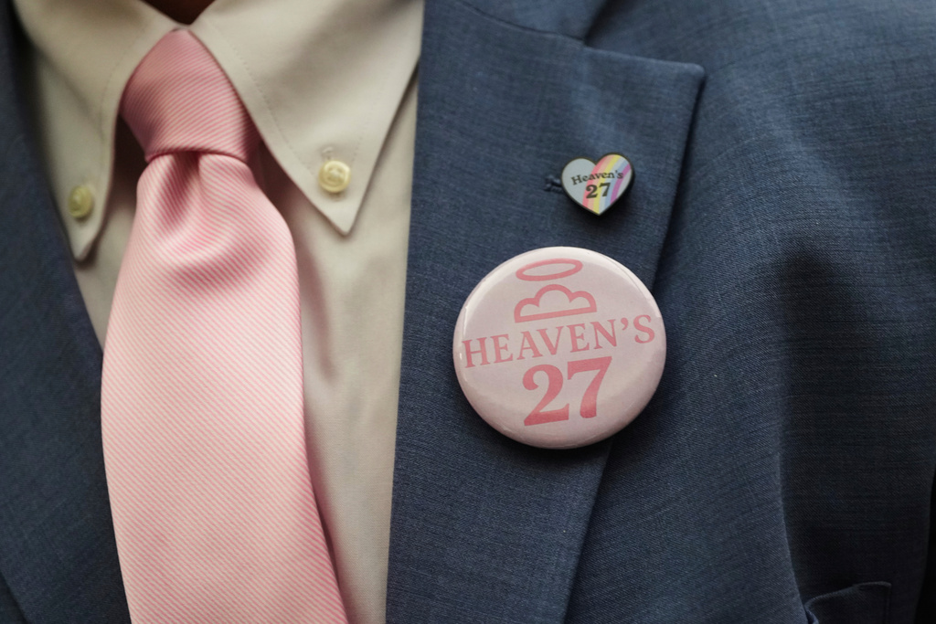 The parent of a child lost to the recent flooding in Kerr County wears a 'Heaven's 27' button during a Texas Senate hearing at the Texas Capitol, Wednesday, Aug. 20, 2025, in Austin, Texas. (AP Photo/Eric Gay)