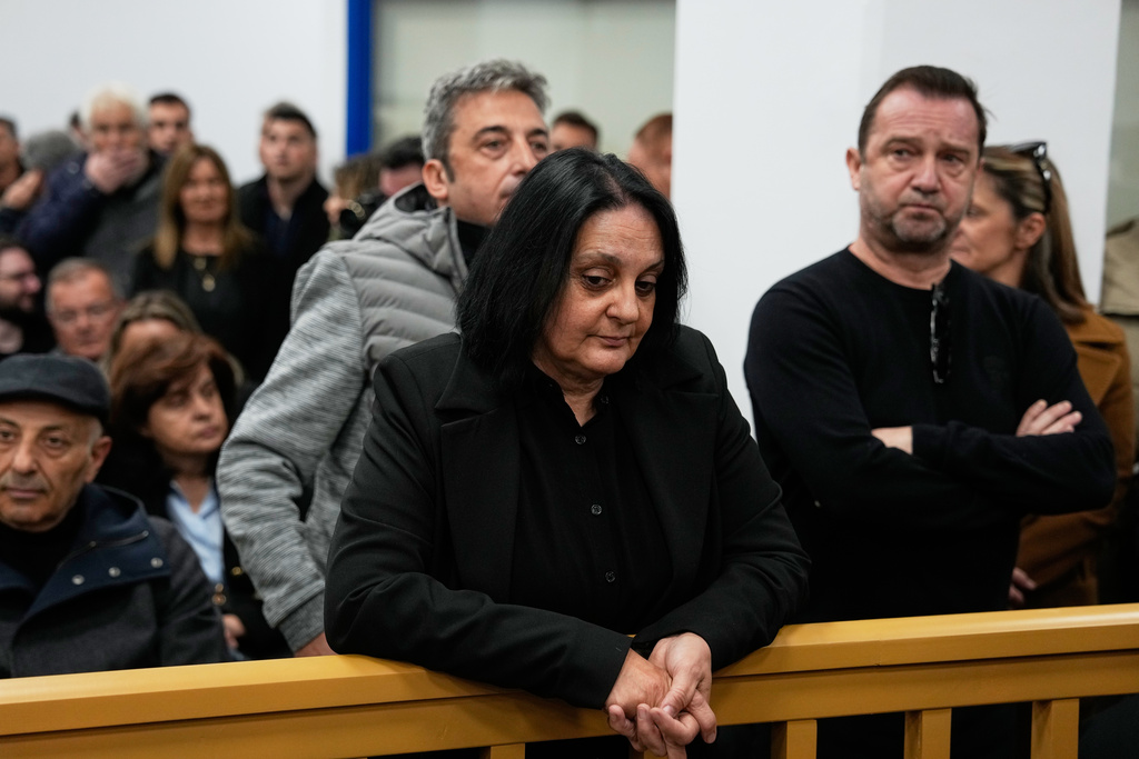 Relatives of victims of the Tempi train crash wait for the trial at the court in Larissa, Greece, Monday, March 23, 2026. (AP Photo/Thanassis Stavrakis)