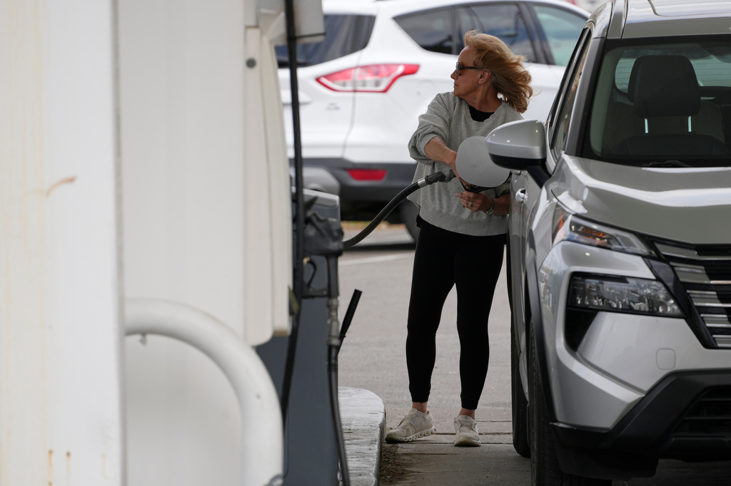 A woman fills her vehicle with fuel at a gas station, Monday, March 30, 2026, in Nashville, Tenn. (AP Photo/George Walker IV)
