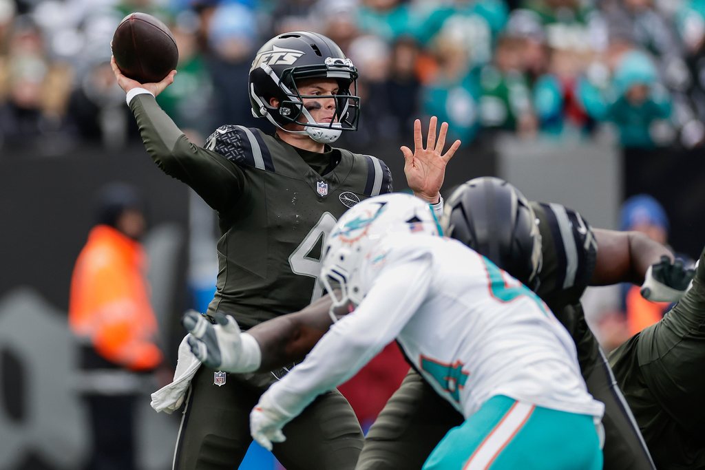 New York Jets quarterback Brady Cook (4) passes against the Miami Dolphins during the second quarter of an NFL football game, Sunday, Dec. 7, 2025, in East Rutherford, N.J. (AP Photo/Adam Hunger)