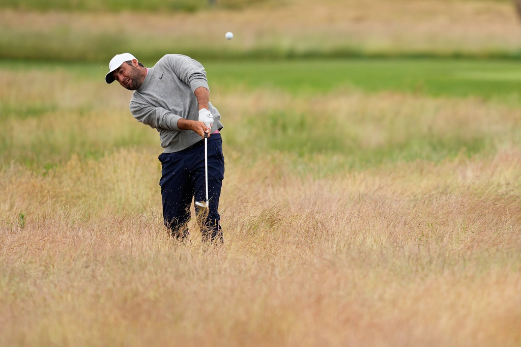 Scottie Scheffler hits from the rough on the fourth hole during the first round of the U.S. Open golf tournament at Shinnecock Hills Golf Club in Southampton, N.Y., Thursday, June 18, 2026.(AP Photo/David J. Phillip)