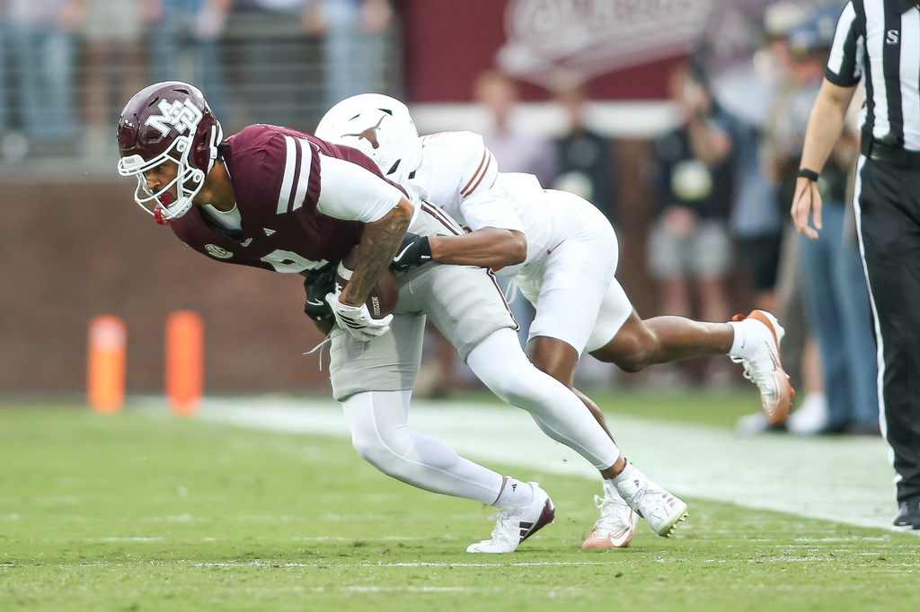 Mississippi State tight end Seydou Traore, left, is tackled by Texas defensive back Malik Muhammad, second from left, during the first half of an NCAA college football game in Starkville, Miss., Saturday, Oct. 25, 2025. (AP Photo/James Pugh)