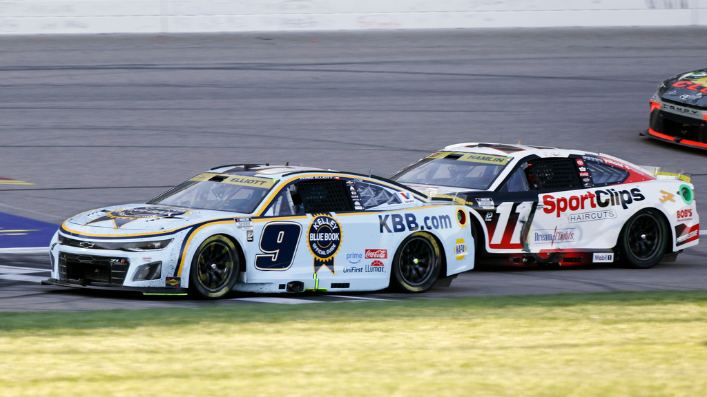 Chase Elliott (9) crosses the finish line to win a NASCAR Cup Series auto race as Denny Hamlin (11) comes in second at Kansas Speedway in Kansas City, Kan., Sunday, Sept. 28, 2025. (AP Photo/Colin E. Braley)