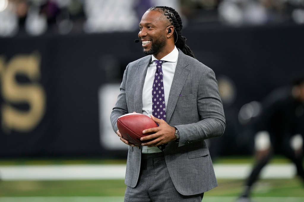 FILE - Larry Fitzgerald Jr. holds a ball on the field before an NFL football game between the New Orleans Saints and the Baltimore Ravens in New Orleans on Nov. 7, 2022. (AP Photo/Gerald Herbert, File)