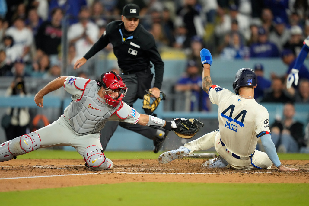 Los Angeles Dodgers' Andy Pages, right, scores on a single by Mookie Betts under the tag of Philadelphia Phillies catcher J.T. Realmuto during the seventhninning of a baseball game Saturday, May 30, 2026, in Los Angeles. (AP Photo/Mark J. Terrill)