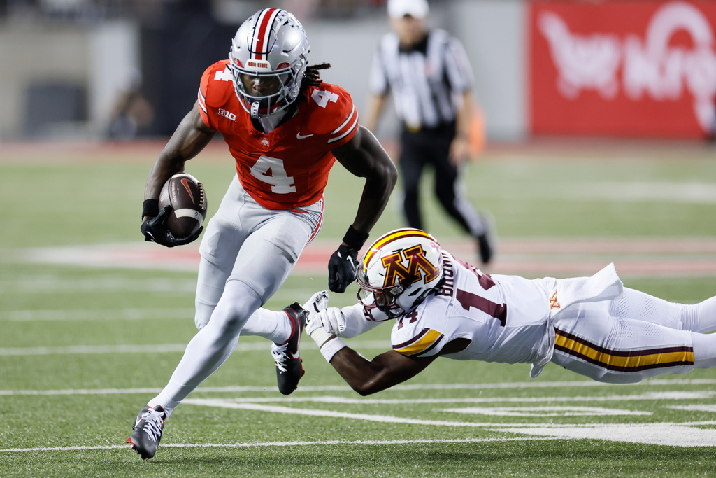 Ohio State receiver Jeremiah Smith, left, runs past Minnesota defensive back Kerry Brown during the first half of an NCAA college football game, Saturday, Oct. 4, 2025, in Columbus, Ohio. (AP Photo/Jay LaPrete)