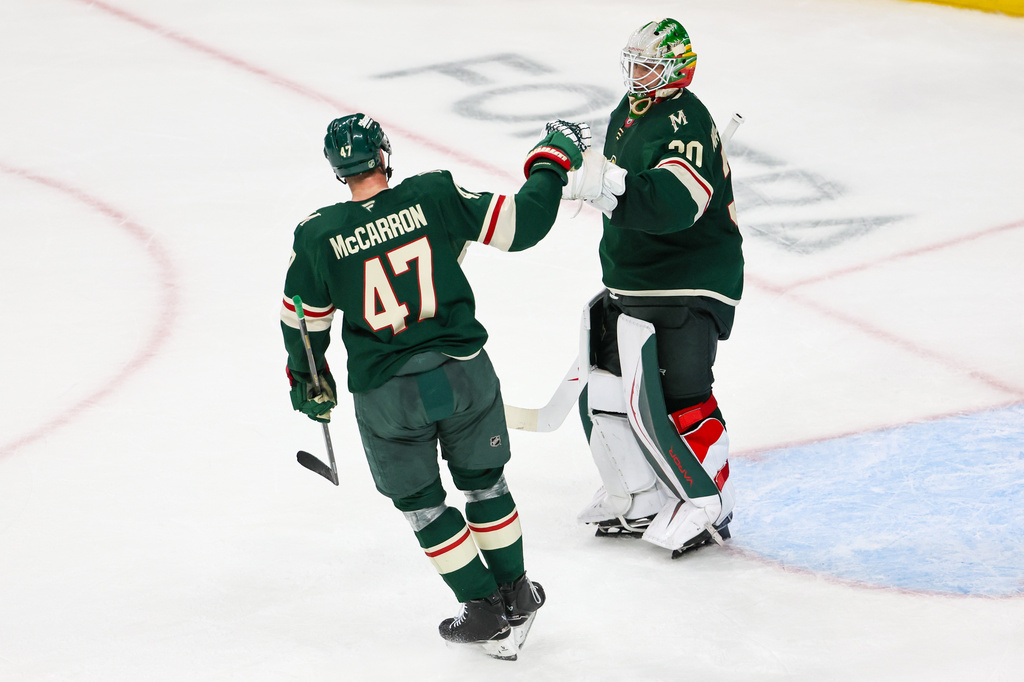 Minnesota Wild center Michael McCarron (47) and Minnesota Wild goaltender Jesper Wallstedt (30) celebrate together after an NHL hockey game Monday, Oct. 12, 2026, in St. Paul, Minn. (AP Photo/Michael Turner)
