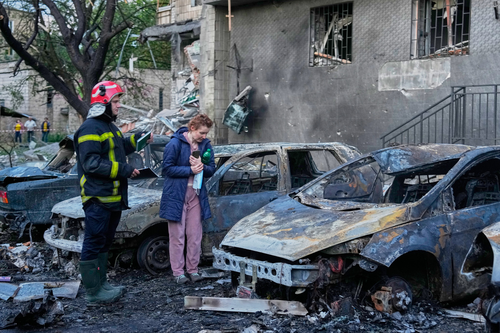An owner looks at her damaged car following a Russia missile attack in Kyiv, Ukraine, Sunday, July 19, 2026. (AP Photo/Efrem Lukatsky)