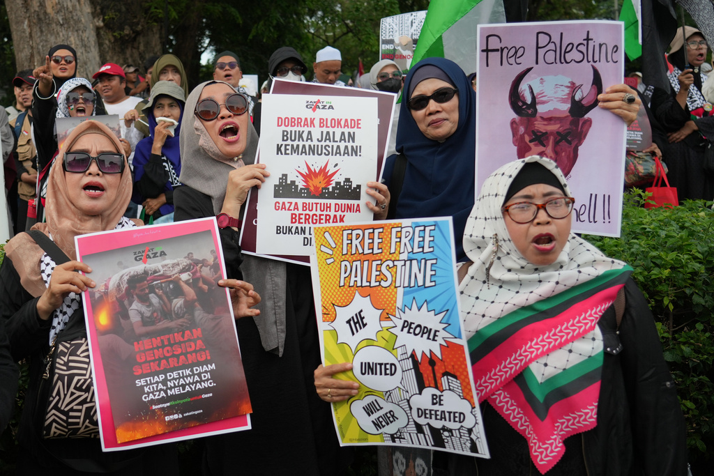 Protesters display posters as they shout slogans during a rally commemorating the second anniversary of the war in Gaza, outside the US Embassy in Jakarta, Indonesia, Tuesday, Oct. 7, 2025. (AP Photo/Achmad Ibrahim)