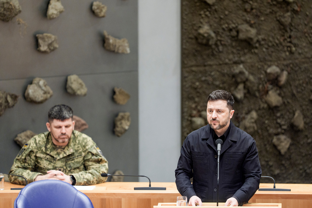 Ukraine's President Volodymyr Zelenskyy, right, delivers a speech during a parliament session in The Hague, Netherlands, Tuesday, Dec. 16, 2025. (Robin van Lonkhuijsen/Pool Photo via AP)