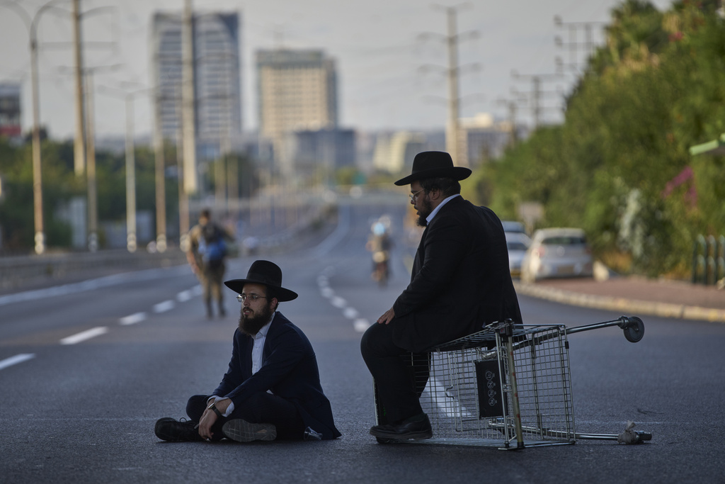 Ultra-Orthodox Jews block a highway during a protest against army recruitment, in Bnei Brak, Israel, Tuesday, Aug. 19, 2025. (AP Photo/Ohad Zwigenberg)