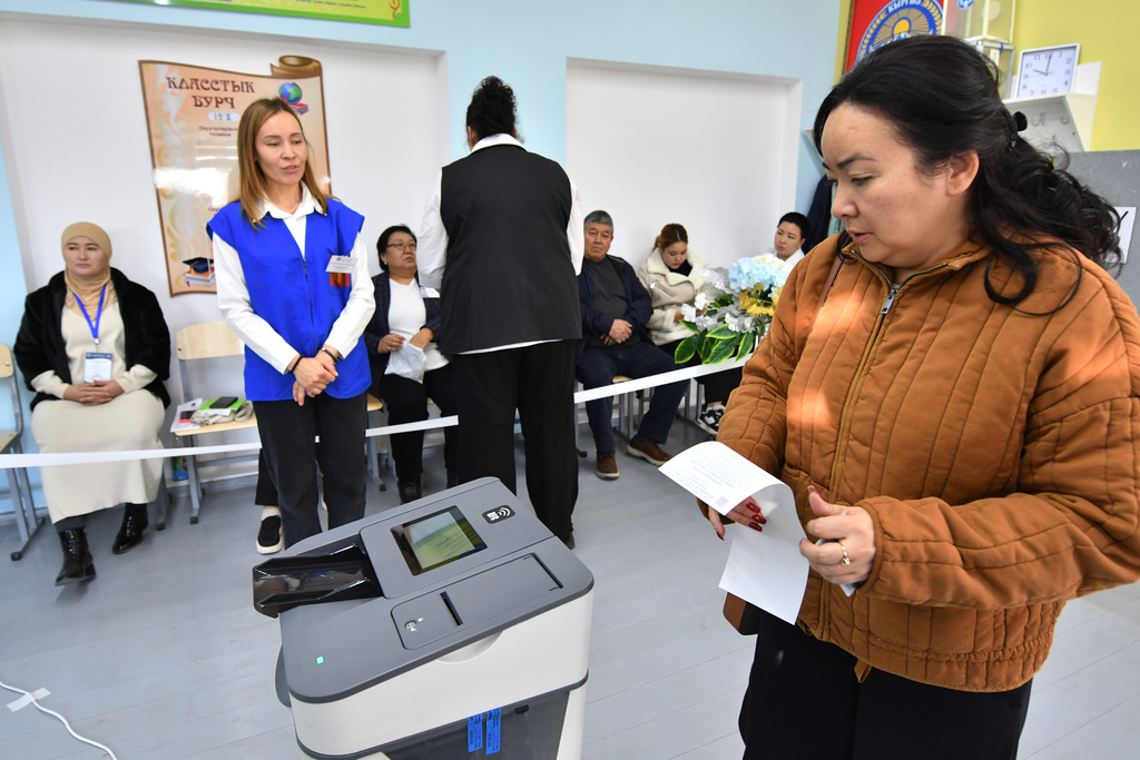 A voter holds a ballot during the parliamentary elections at a polling station in Tash-Dobo, south of Bishkek, Kyrgyzstan, Sunday, Nov. 30, 2025. (AP Photo/Vladimir Voronin)